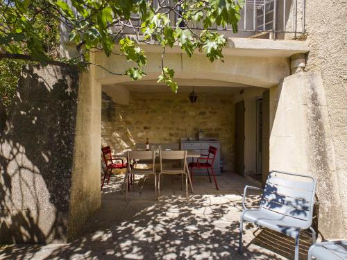 un patio avec une table et des chaises dans un bâtiment dans l'établissement La Maison de Juliette, à Maussane-les-Alpilles