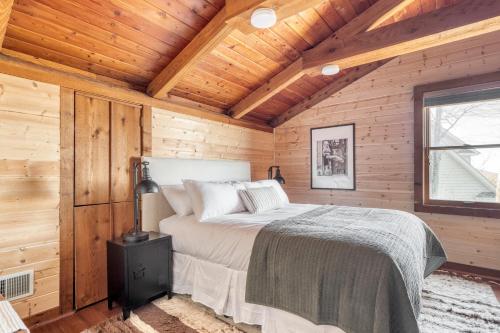 a bedroom with a bed in a wooden cabin at Pine Needle by AvantStay Log Cabin w Gorgeous Views Hot Tub Patio Pool Table in Gatlinburg