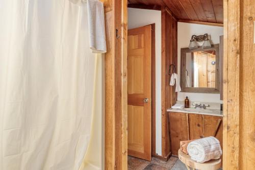 a bathroom with a shower curtain and a sink at Pine Needle by AvantStay Log Cabin w Gorgeous Views Hot Tub Patio Pool Table in Gatlinburg