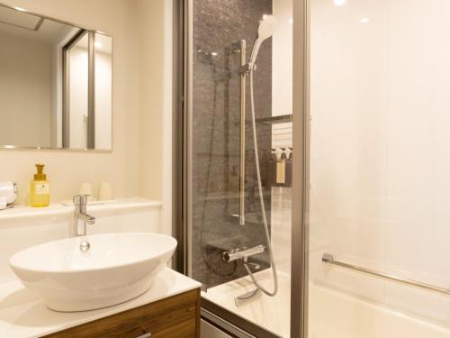 a white bathroom with a sink and a shower at Kurayoshi City Hotel in Kurayoshi