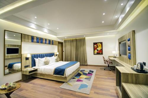 una camera d'albergo con letto e scrivania di Cygnett Style Ganga a Jaipur