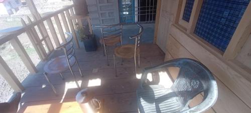 2 Stühle und ein Tisch auf einer Veranda in der Unterkunft Himalayan Home stay in Bāgeshwar