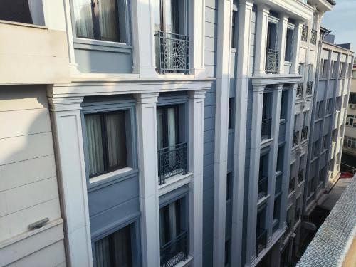 Hotel Esve Istanbul في إسطنبول: مبنى شبابيكه وشرفات على شارع