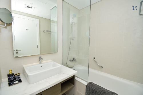 a white bathroom with a sink and a shower at Canal View Studio Apartments - DAMAC Prive Business Bay in Dubai