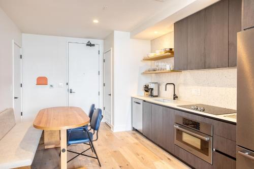 a kitchen with a wooden table and blue chairs at Saxon by AvantStay Brand New Condo in Austin w Amazing Amenities in Austin