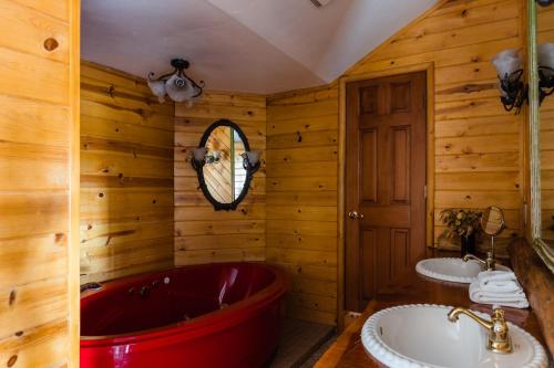 een badkamer met 2 wastafels en een rood bad bij Gambler by AvantStay Charming Spacious Cabin 5 Min Walk to Lake in Big Bear Lake