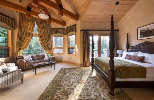 1 dormitorio con cama, sofá y ventanas en Cherry Ridge by AvantStay Incredible Mountain Mansion w Game Room Hot Tub Views, en Breckenridge