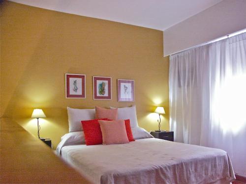 a bedroom with a bed with red and white pillows at Loft Argentino Apart Buenos Aires in Buenos Aires
