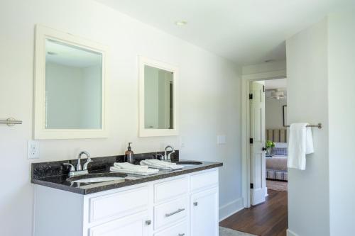 La salle de bains est pourvue de 2 lavabos et d'un miroir. dans l'établissement Jessamine by AvantStay Picture Perfect Home w Stunning Backyard, à Isle of Palms