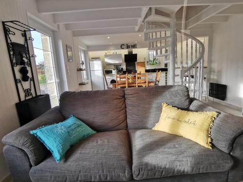 ein Wohnzimmer mit einem braunen Sofa mit zwei Kissen in der Unterkunft Gîte Tromenec in Landunvez