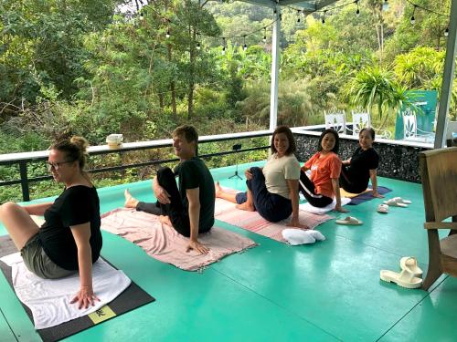 eine Gruppe von Menschen, die in einem Yoga-Kurs auf dem Boden sitzen in der Unterkunft Cat Ba Love House in Cát Bà