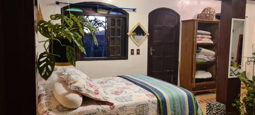 een slaapkamer met een bed en een potplant bij Red Rose in Cabo Frio