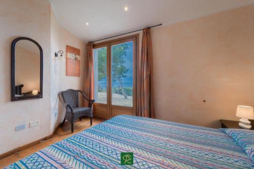 a bedroom with a bed and a chair and a window at Villa Tiziana in Casa Morcone