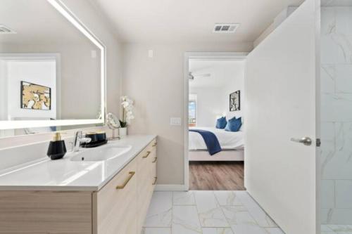 uma casa de banho com um lavatório, um espelho e uma cama em Luxurious SM Penthouse with Panoramic Ocean Views em Los Angeles