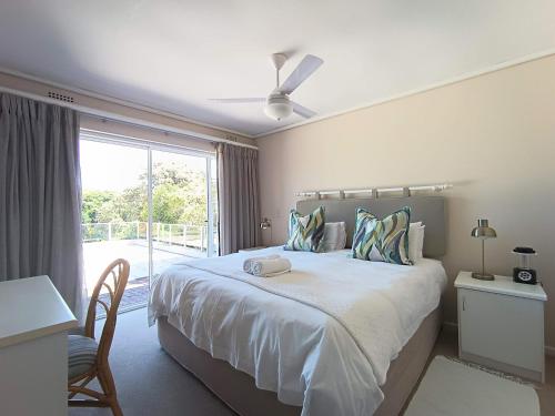 a bedroom with a large bed with a window at Villa Azure - Sea Views, Pool - 70m onto Robberg 5 Beach in Plettenberg Bay