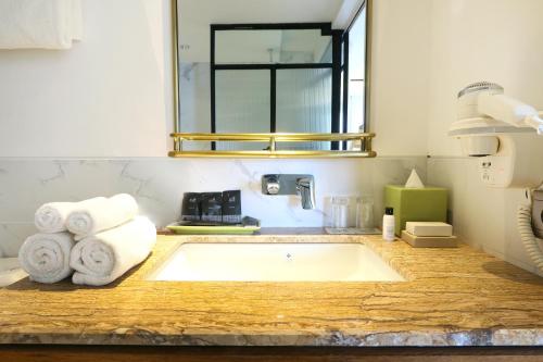 a bathroom with a bath tub with towels on a counter at Java Paragon Hotel & Residences in Surabaya