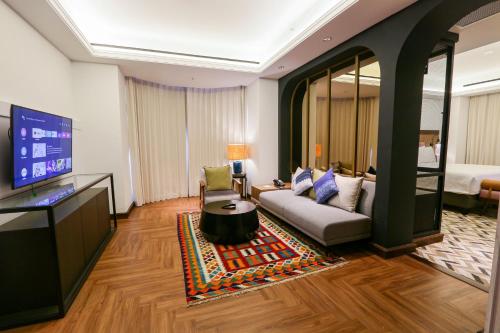 a living room with a couch and a tv at Java Paragon Hotel & Residences in Surabaya