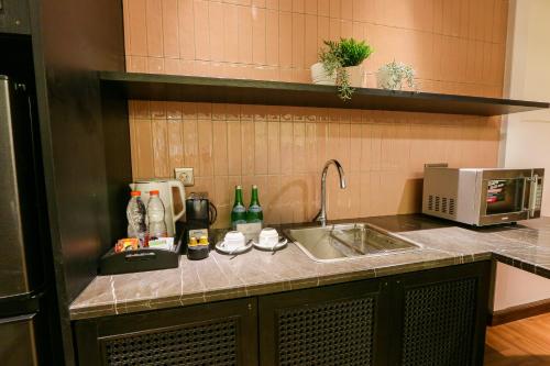 a kitchen counter with a sink and a microwave at Java Paragon Hotel & Residences in Surabaya
