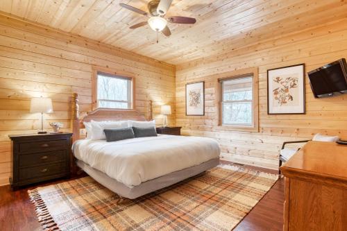 - une chambre avec un lit et un ventilateur de plafond dans l'établissement Ashberry by AvantStay Large Cabin Surrounded in Pine Tree w River Views Game Room, à Gatlinburg