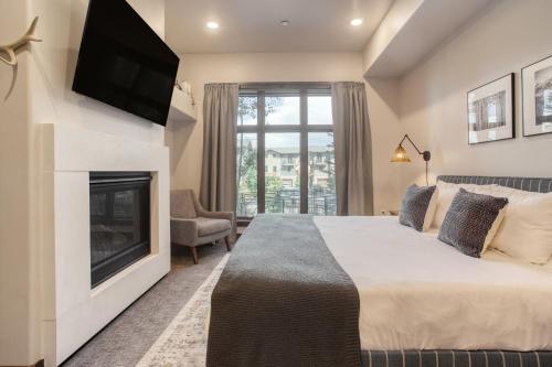 a bedroom with a large bed and a fireplace at Kestrel by AvantStay Close to the Ski Slopes in this Majestic Home in Park City in Park City