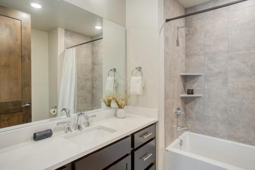a bathroom with a sink and a mirror and a tub at Kestrel by AvantStay Close to the Ski Slopes in this Majestic Home in Park City in Park City