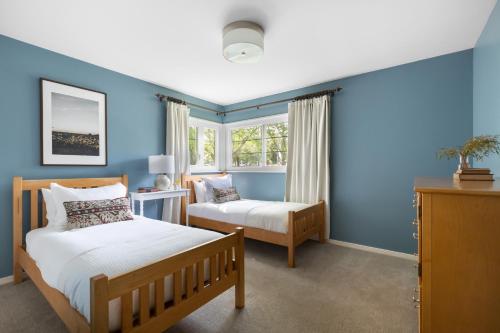 - une chambre avec 2 lits et des murs bleus dans l'établissement Wildflower by AvantStay Gorgeous Wine Country Home w Pool Bocce Ball Court Huge Yard, à Boyes Hot Springs