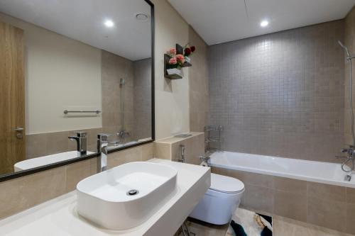 a bathroom with a sink and a toilet and a mirror at HomesGetaway- Stylish 1BR in 1 Residence Al Kifaf Tower 1 in Dubai