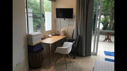 a room with a desk with a chair and a window at Bangpo Village Tiny Country Beach House in Ban Bang Po