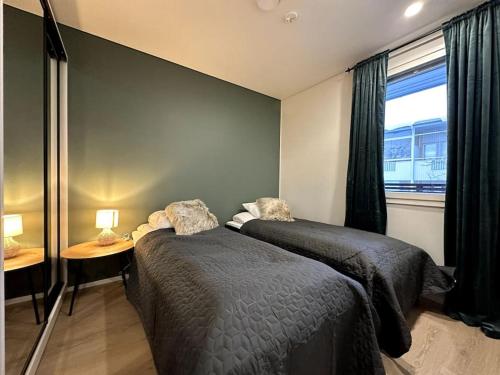 een slaapkamer met 2 bedden, een tafel en een raam bij Kotimaailma Apartments#5 - Boheemi kaksio keskustassa in Seinäjoki