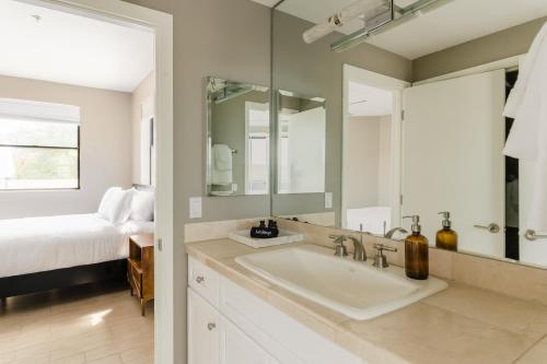 a bathroom with a sink and a mirror and a bed at Ivory Buyout By AvantStay Two Home Buyout Near Old Town w Large Patio in Scottsdale