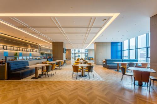 a lobby of a hotel with tables and chairs at Holiday Inn Express Heze City Center, an IHG Hotel in Heze