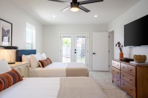 a bedroom with two beds and a flat screen tv at Rosario by AvantStay10mins to Old Town Scottsdale w Hot Tub in Scottsdale