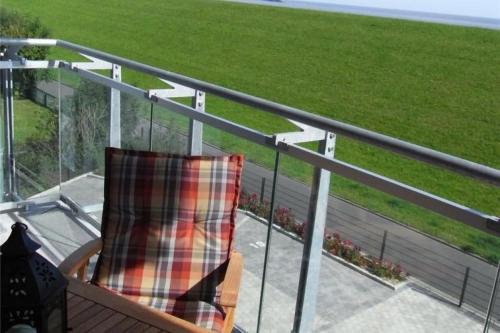 a chair on a balcony with a view of a field at Döser Seedeich 7, SD2 in Cuxhaven