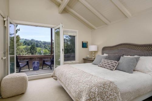 a bedroom with a large bed and a balcony at Chapman Cove by AvantStay Gorgeous Beach Bungalow w Sauna in Cannon Beach