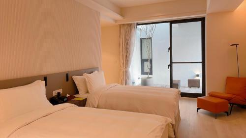 een hotelkamer met 2 bedden en een raam bij AQUA Tree Resort in Fengbin