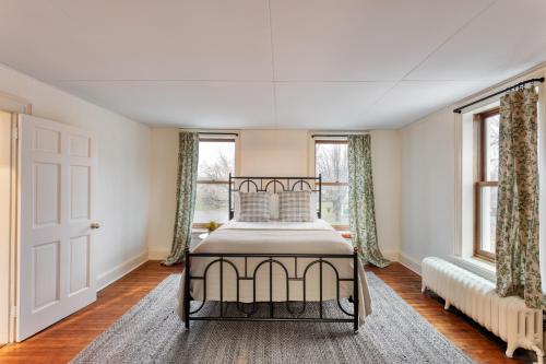 um quarto com uma cama e duas janelas em Elliot by AvantStay Historic Character Home in Great Location em Saugerties