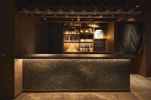 a bar in a restaurant with a counter top at SAKE Kura Hotel 川崎宿 in Kawasaki