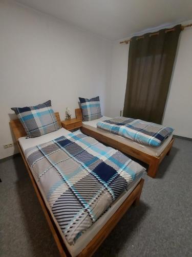 dwa łóżka siedzące obok siebie w pokoju w obiekcie Selb Ferienwohnungen w mieście Selb