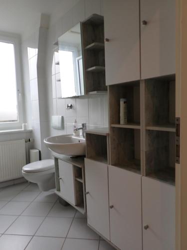 ein weißes Bad mit einem Waschbecken und einem WC in der Unterkunft Liebigstraße 25 in Mülheim an der Ruhr