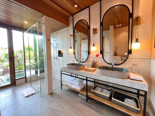 - Baño con 2 lavabos y 2 espejos en The Ridge Bali, en Ubud