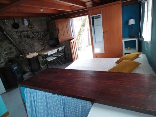 1 dormitorio con 1 cama y escritorio en una habitación en La cabañina de zuce, en Parres de Llanes