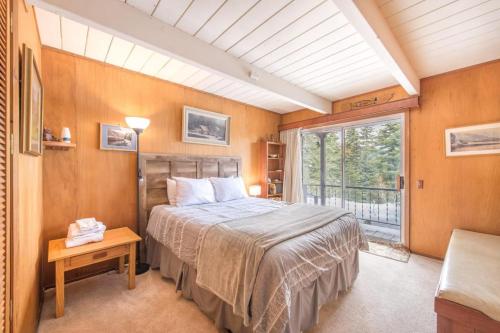 1 dormitorio con cama y ventana grande en Mahogany by AvantStay Snowbird Cabin w Full Chamberlands Access, en Homewood