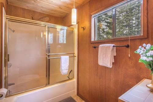 baño con ducha y puerta de cristal en Mahogany by AvantStay Snowbird Cabin w Full Chamberlands Access, en Homewood