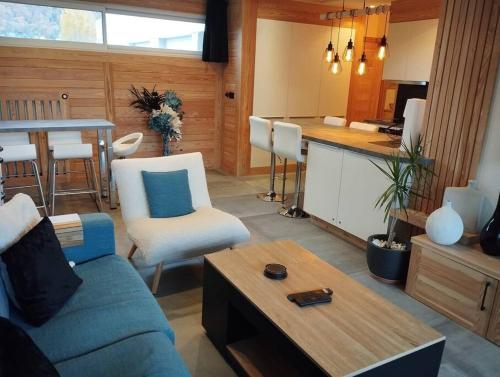 a living room with a blue couch and a table at Magnifique Apt à deux pas du lac et près du centre in Annecy