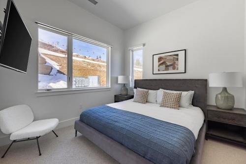ein Schlafzimmer mit einem Bett, einem Stuhl und einem Fenster in der Unterkunft Silverado by AvantStay Snowboarders Skiers Paradise w Hot Tub Views Easy Slope Access in Park City