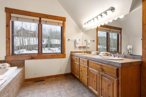 a bathroom with a large sink and two windows at Russell Home by AvantStay Expansive Deck Stunning Views Hot Tub in Telluride