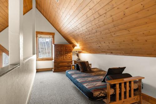 een slaapkamer met een bed en een houten plafond bij Russell Home by AvantStay Expansive Deck Stunning Views Hot Tub in Telluride