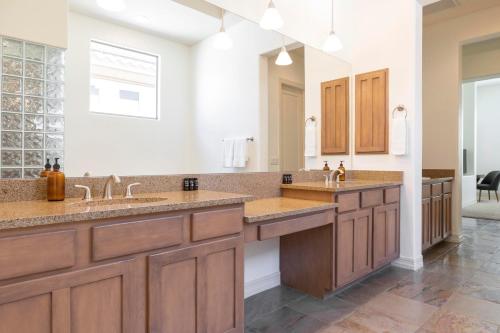 a large bathroom with two sinks and a large mirror at Sandflower by AvantStay Oasis w Pool Golf in Phoenix