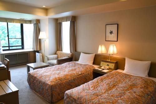 嬬戀的住宿－Karuizawakurabu Hotel 1130 Hewitt Resort，酒店客房,配有两张床和椅子