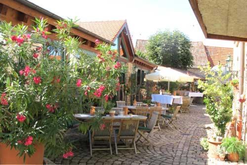 eine Außenterrasse mit Tischen, Stühlen und Blumen in der Unterkunft Seyberth´s Chalet in Siefersheim